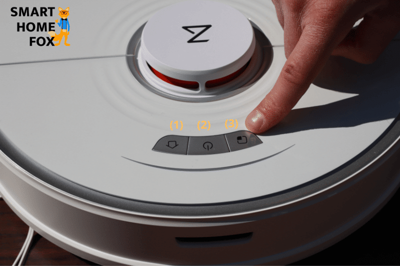 Ein Finger zeigt auf die Steuerungsknöpfe des Roborock S7